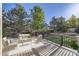 Deck with outdoor seating and views of the backyard with mature trees and green grass at 2660 Timberchase Trl, Highlands Ranch, CO 80126