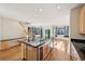 Kitchen island with breakfast bar, stainless steel appliances, and hardwood flooring at 2660 Timberchase Trl, Highlands Ranch, CO 80126