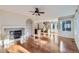 Open living room with fireplace, hardwood floors, and large windows providing plenty of natural light at 2660 Timberchase Trl, Highlands Ranch, CO 80126
