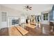 Cozy living room with a fireplace, hardwood floors, and open access to the kitchen at 2660 Timberchase Trl, Highlands Ranch, CO 80126