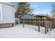 Wooden fence encloses a portion of the snowy backyard at 10401 W Lehigh Ave, Denver, CO 80235