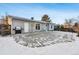 Backyard patio with partial snow cover and grill at 10401 W Lehigh Ave, Denver, CO 80235