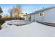 Backyard patio, partially covered in snow, near home exterior at 10401 W Lehigh Ave, Denver, CO 80235