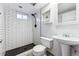 Basement bathroom with subway tile shower and pedestal sink at 10401 W Lehigh Ave, Denver, CO 80235