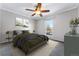 Spacious bedroom with ceiling fan and large window at 10401 W Lehigh Ave, Denver, CO 80235