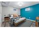 Finished basement bedroom with teal accent wall and wood-look flooring at 10401 W Lehigh Ave, Denver, CO 80235