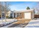 Ranch style home with driveway and attached garage, winter scene at 10401 W Lehigh Ave, Denver, CO 80235