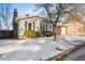 House exterior showcasing a snow-covered yard and landscaping at 10401 W Lehigh Ave, Denver, CO 80235