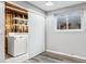 Basement laundry room with sliding barn door and shelving at 10401 W Lehigh Ave, Denver, CO 80235