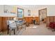 Cozy den with wood-paneled walls, neutral carpet, and a glimpse into another room at 10039 S Turkey Creek Rd, Morrison, CO 80465