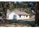 Quaint home with light siding, a wooden deck, and lush trees providing shade on a sunny day at 10039 S Turkey Creek Rd, Morrison, CO 80465