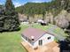 Eye-level exterior view of ranch style home with a spacious wooden deck and a well maintained lawn at 10039 S Turkey Creek Rd, Morrison, CO 80465