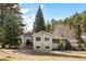 Spacious home with neutral siding, surrounded by mature trees, a well-maintained yard and driveway at 10039 S Turkey Creek Rd, Morrison, CO 80465