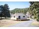 Charming home with a wooden deck, light siding, well kept lawn, and a backdrop of lush trees at 10039 S Turkey Creek Rd, Morrison, CO 80465