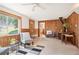 Inviting living room featuring wood paneling, a cozy wood-burning stove, and a large window with scenic views at 10039 S Turkey Creek Rd, Morrison, CO 80465