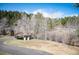Small outbuilding surrounded by trees and a road, set against a backdrop of greenery at 10039 S Turkey Creek Rd, Morrison, CO 80465