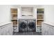 Basement laundry room with white cabinets, LG washer and dryer, and built-in shelving at 727 Niagara St, Denver, CO 80220