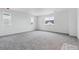 Open bonus room with neutral carpet and a large window offering lots of natural light at 9297 Truckee Ct, Commerce City, CO 80022