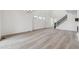 Bright and airy living room with elegant chandelier, modern staircase, and wood floors at 9297 Truckee Ct, Commerce City, CO 80022