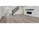 Open-concept living space with light-colored wood flooring and modern staircase at 9297 Truckee Ct, Commerce City, CO 80022