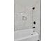 Updated bathtub featuring white tile surround and modern fixtures at 7018 Reed Ct, Arvada, CO 80003