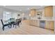 Open dining room with hardwood floors, modern light fixture, and wine fridge at 7018 Reed Ct, Arvada, CO 80003