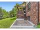 Beautiful backyard featuring a brick house, a covered porch, and a large grassy area at 7863 W Friend Dr, Littleton, CO 80128