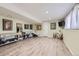 Spacious finished basement with modern furniture and light wood flooring at 7863 W Friend Dr, Littleton, CO 80128