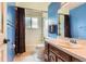 This bathroom features a tub and shower combo, blue accent walls, and updated fixtures at 7863 W Friend Dr, Littleton, CO 80128