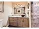 Bathroom featuring a granite counter, wood cabinets, and updated shower at 7863 W Friend Dr, Littleton, CO 80128