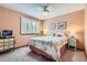 This bedroom features a ceiling fan, shuttered windows, and standard closet space at 7863 W Friend Dr, Littleton, CO 80128