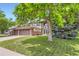 Charming two-story home with a well-manicured lawn and mature shade tree in the front yard at 7863 W Friend Dr, Littleton, CO 80128