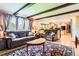 Inviting living room with beamed ceilings and an open view to the updated kitchen at 7863 W Friend Dr, Littleton, CO 80128
