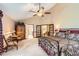A main bedroom offers a ceiling fan, carpeted floors, a decorative furniture set, and entry to an ensuite bathroom at 7863 W Friend Dr, Littleton, CO 80128