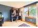 Bright home office featuring a built-in desk and hutch, hardwood floors, and a large window at 7863 W Friend Dr, Littleton, CO 80128