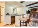 Stylish wet bar featuring glass shelving, pendant lighting, and seating at 7863 W Friend Dr, Littleton, CO 80128