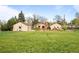 View of the expansive backyard, mature trees, patio, deck, and outbuildings at 435 Balsam St, Lakewood, CO 80226