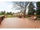 Expansive wooden deck with outdoor seating, overlooking a landscaped backyard with mature trees at 435 Balsam St, Lakewood, CO 80226
