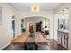 Open-concept dining room with a large wood table, chandelier, and views into the kitchen and living room at 435 Balsam St, Lakewood, CO 80226