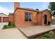 Close-up of brick home showcasing the front patio with outdoor seating and tidy landscaping at 435 Balsam St, Lakewood, CO 80226