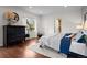 Serene main bedroom boasts dark hardwood floors, an ornate dresser, and a sunny window, offering a cozy retreat at 435 Balsam St, Lakewood, CO 80226