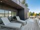 Relaxing deck with modern lounge chairs, wood floors, and a view of the surrounding trees at 4432 Umatilla St, Denver, CO 80211
