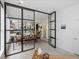 Modern dining area with an open floor plan featuring black-trimmed glass walls that allow for ample natural light at 4432 Umatilla St, Denver, CO 80211