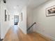Bright hallway with hardwood floors, leading to rooms with black-framed glass doors and staircase at 4432 Umatilla St, Denver, CO 80211