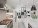 Modern kitchen featuring stainless steel appliances, white cabinetry, marble countertops, and open access to living spaces at 4432 Umatilla St, Denver, CO 80211