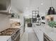 Modern kitchen featuring stainless steel appliances, white cabinetry, marble countertops, and open access to living spaces at 4432 Umatilla St, Denver, CO 80211