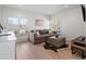 Bright living room with hardwood floors, neutral colors, and a plush couch by window at 4432 Umatilla St, Denver, CO 80211