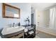 Bright bathroom features a tub with shower, light blue walls and a modern vanity at 1929 S Xanadu Way, Aurora, CO 80014