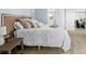 Bedroom with woven headboard, patterned coverlet, side table, and wood floors at 1929 S Xanadu Way, Aurora, CO 80014