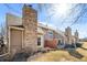 Exterior angle of a townhome with a stone chimney and small backyard at 1929 S Xanadu Way, Aurora, CO 80014